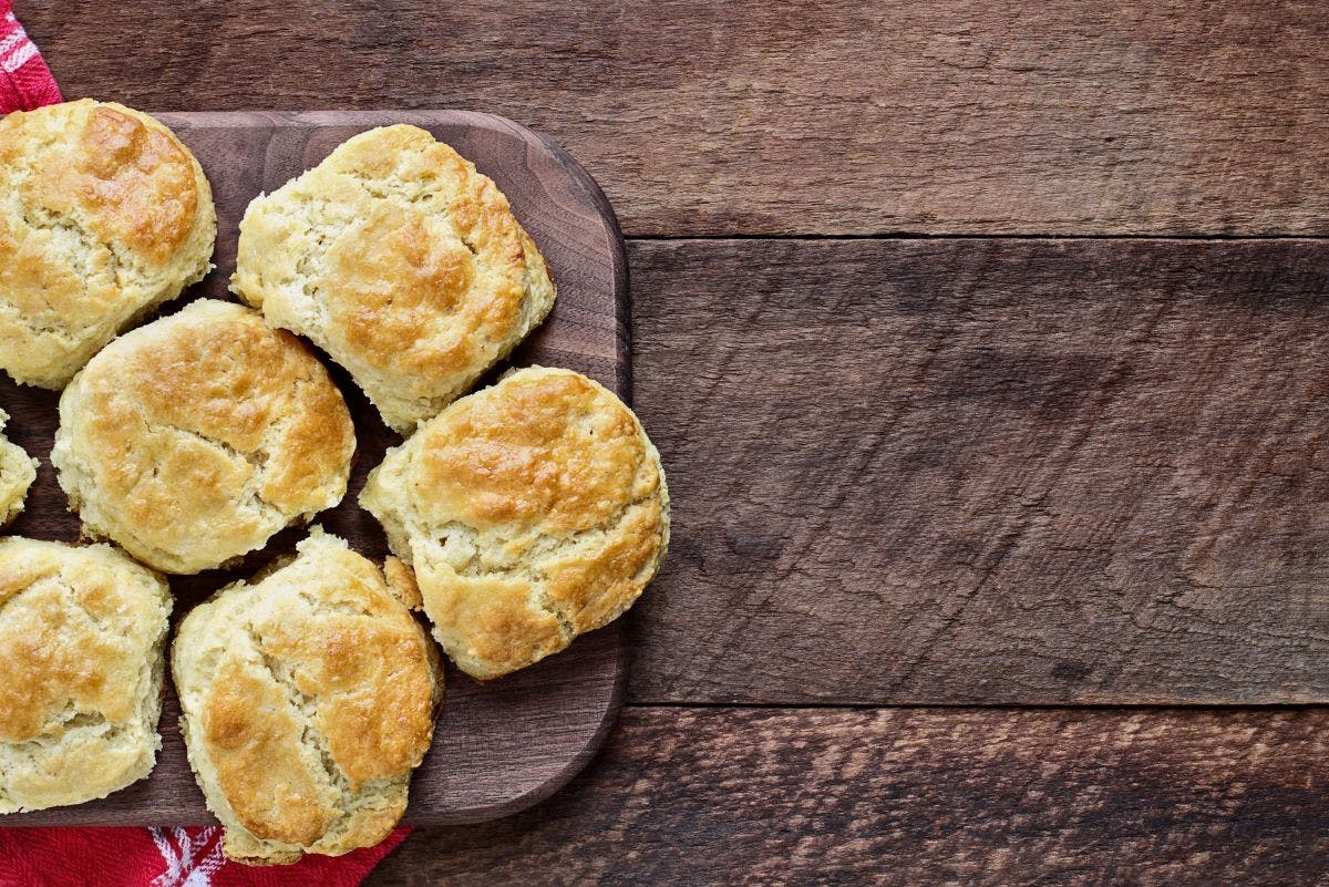 Buttermilk biscuits on a rustic wooden table.