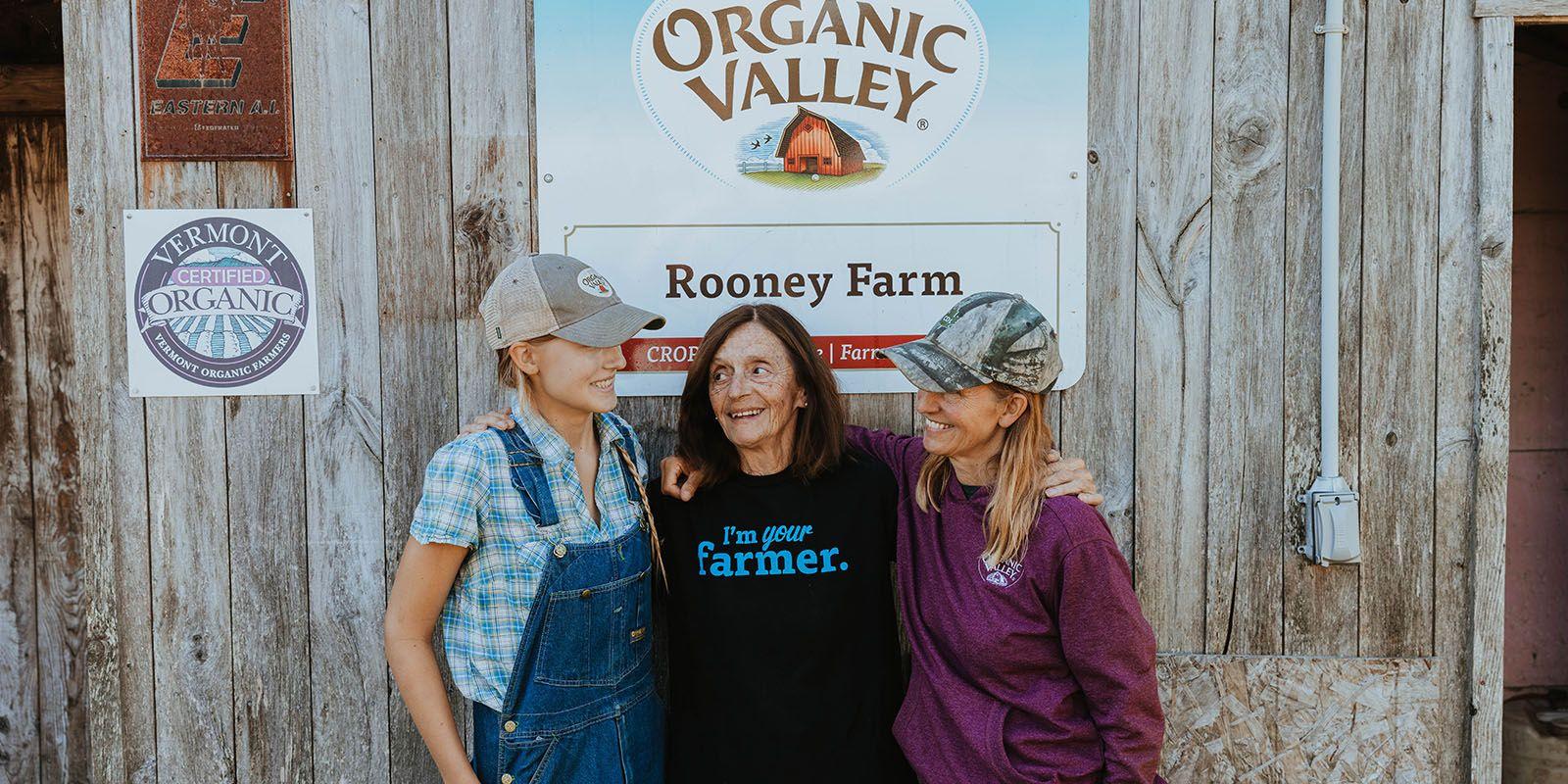 The Rooney family stands by a barn.