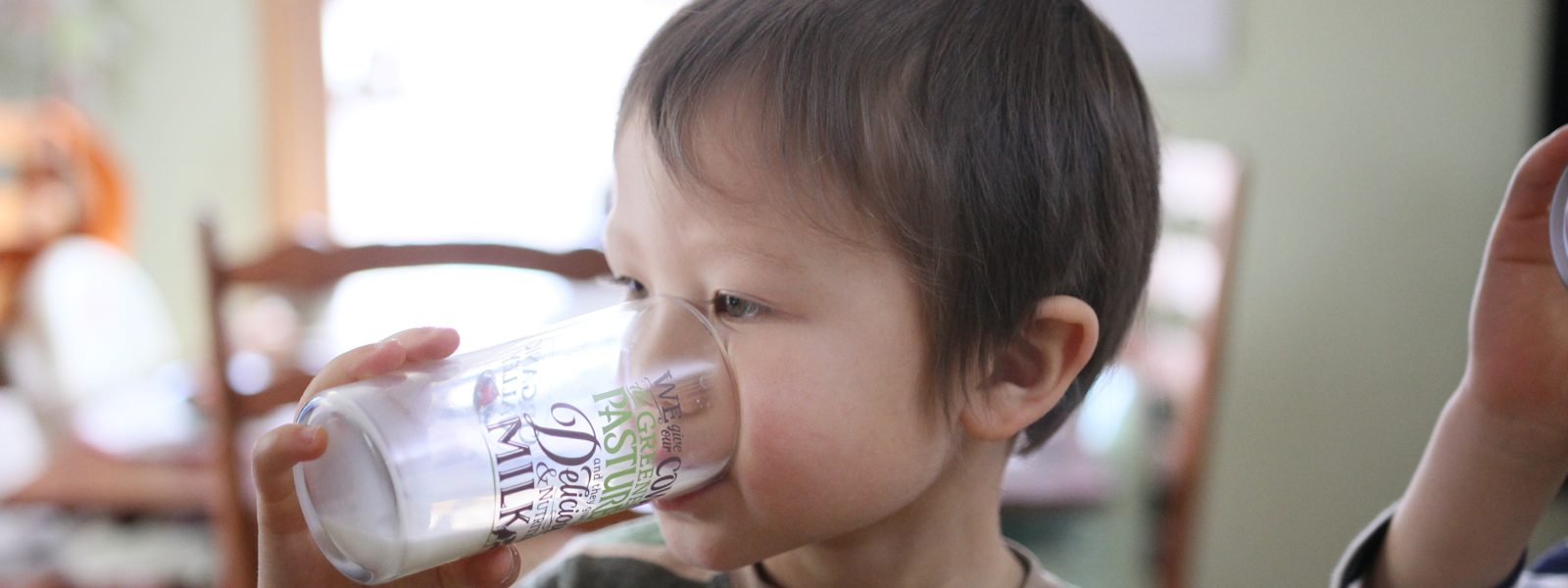 A child drinks milk from a glass.