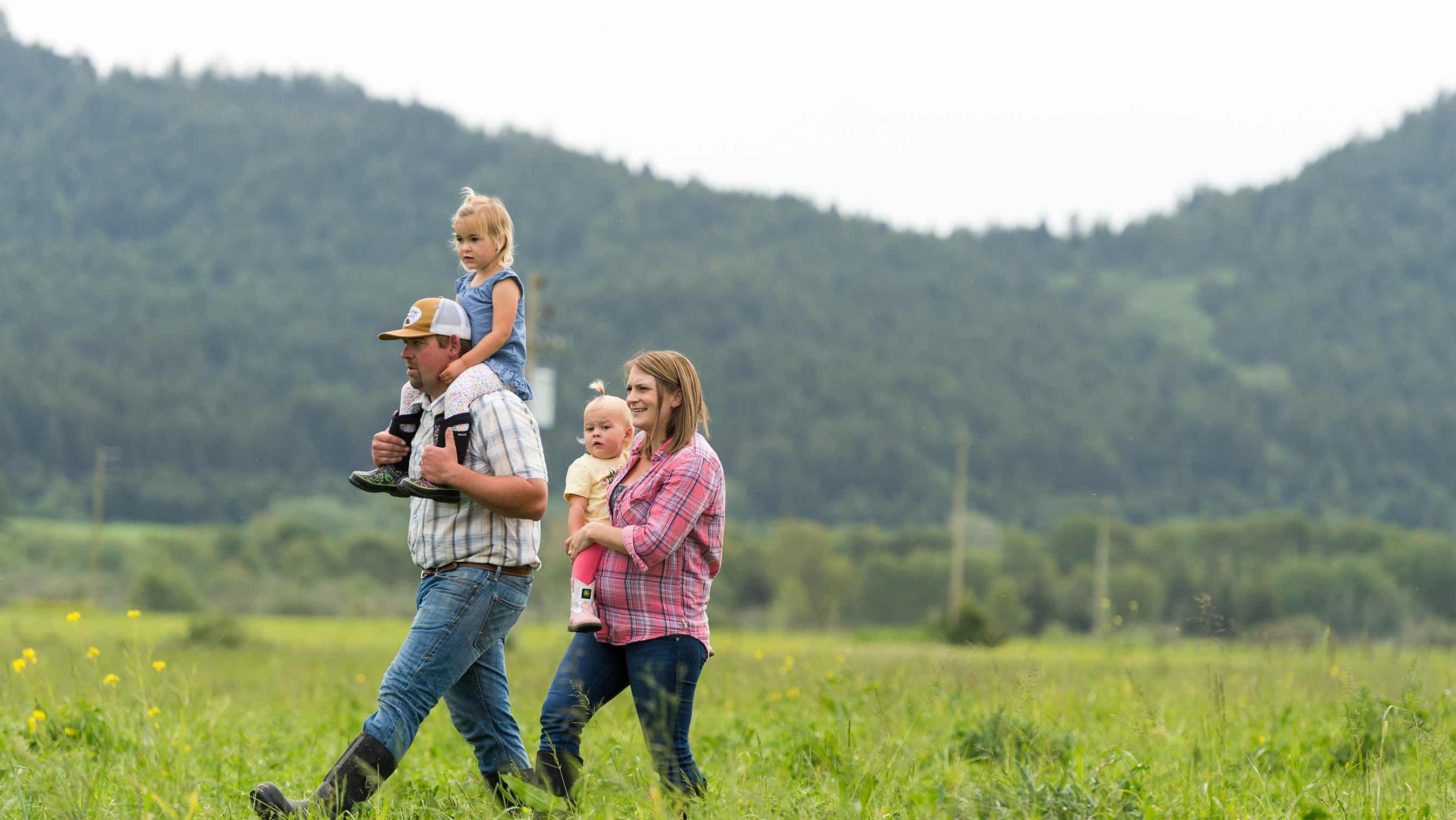 The Bess family walking in the pasture on their Organic Valley family farm