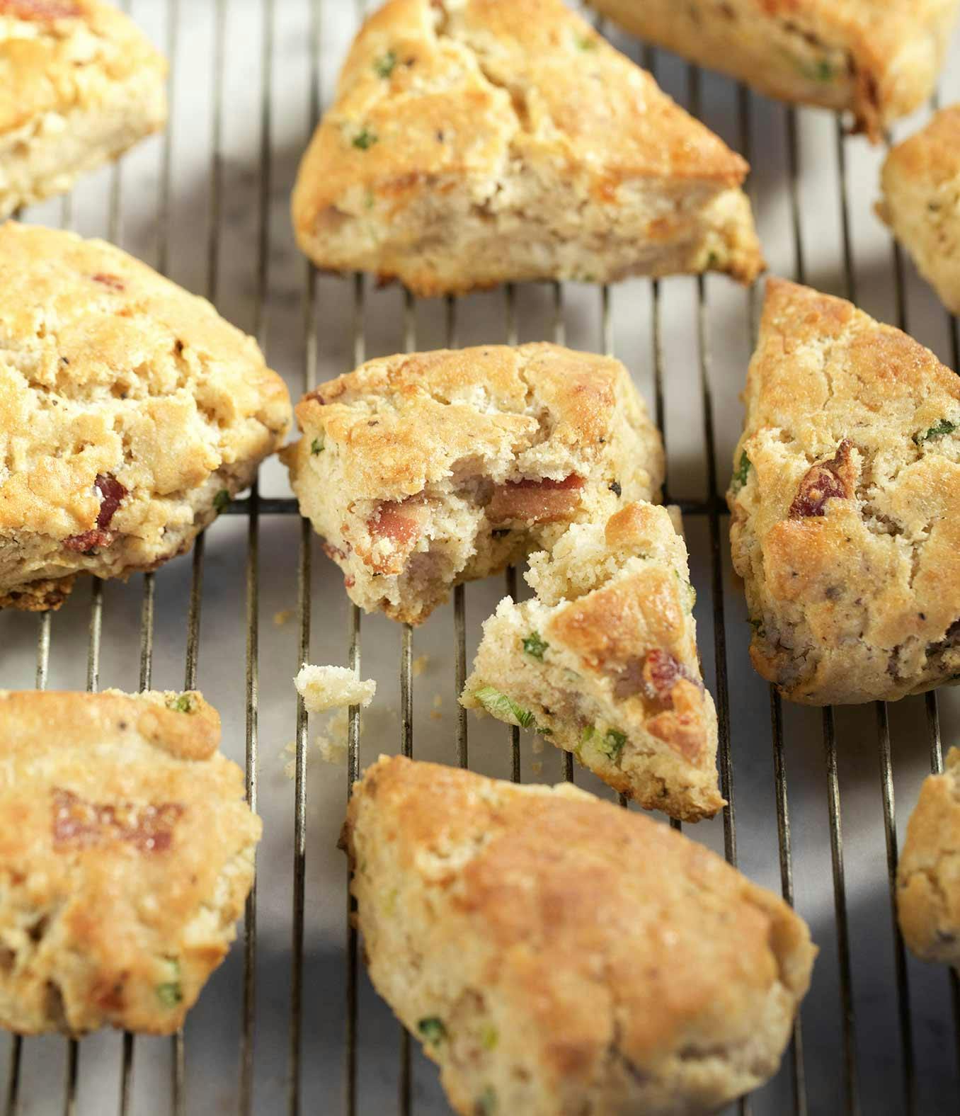 Gluten-Free Bacon and Cheddar Scones on a wire rack with one broken in half.