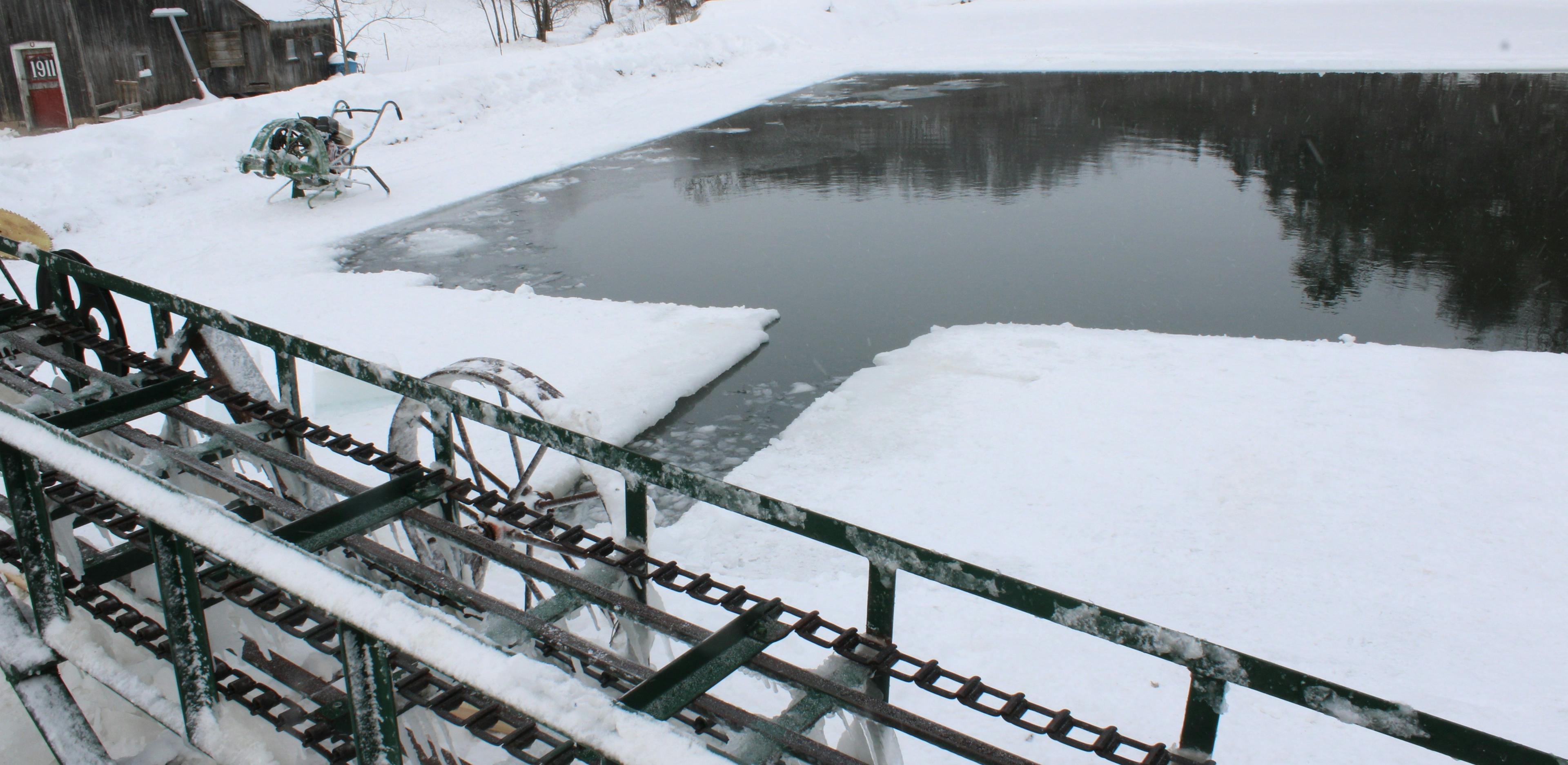 An elevator to move ice blocks sits by a pond that Amish men cut ice blocks from.