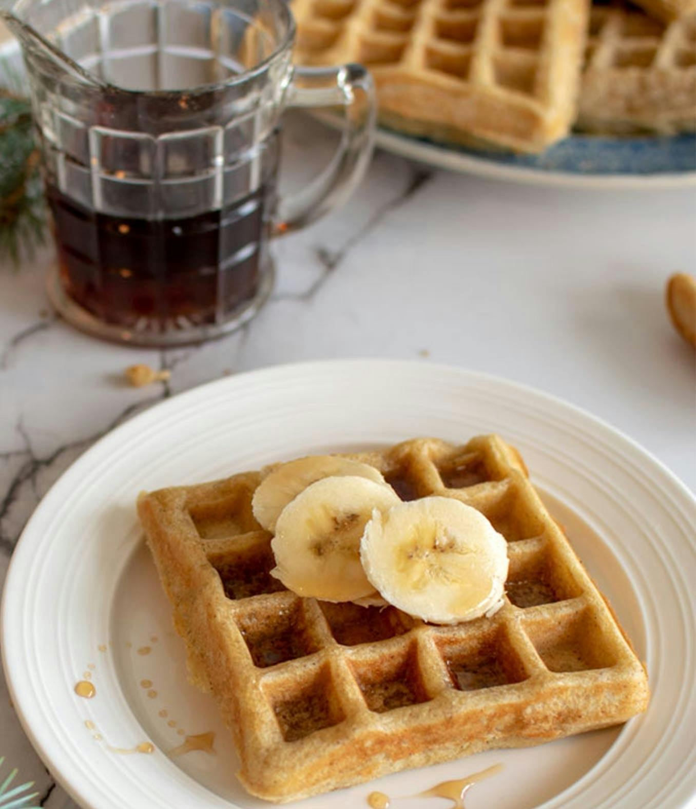 Eggnog waffles with banana and syrup.